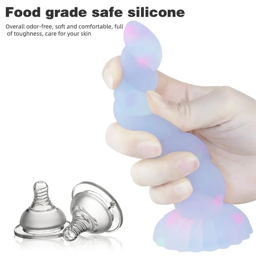 Rear or angled view of dark glowing toy for women with suction cup for pleasure